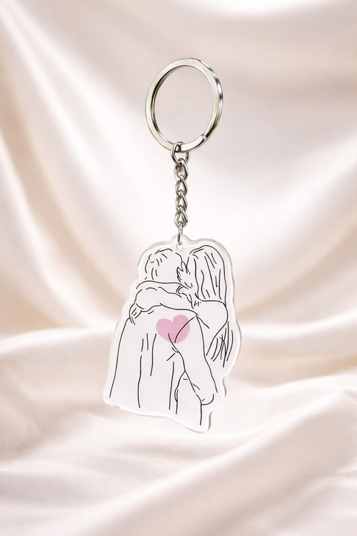 Keychain with a design of two people hugging and a heart on a pink satin background